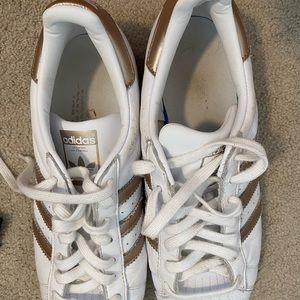 gold and white adidas sneakers